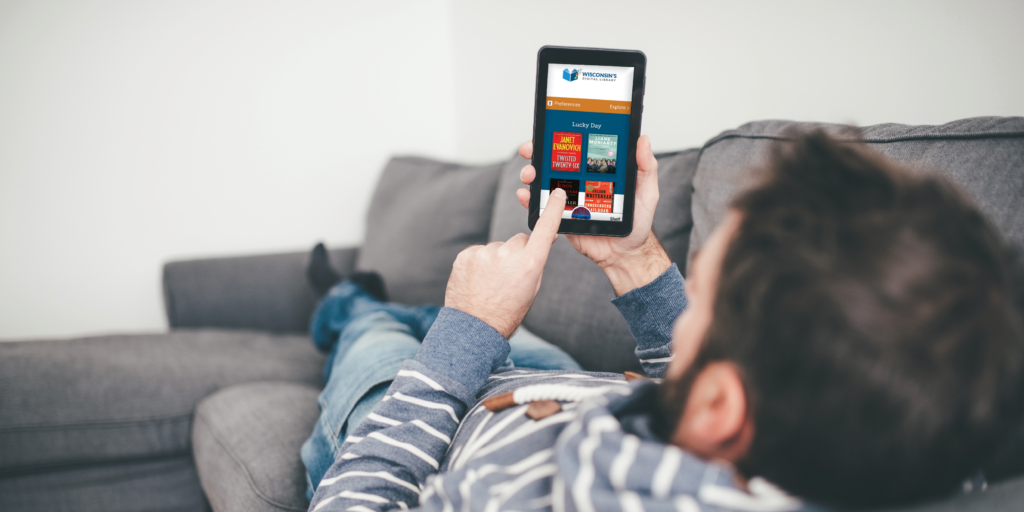 Man laying on a couch using a smartphone